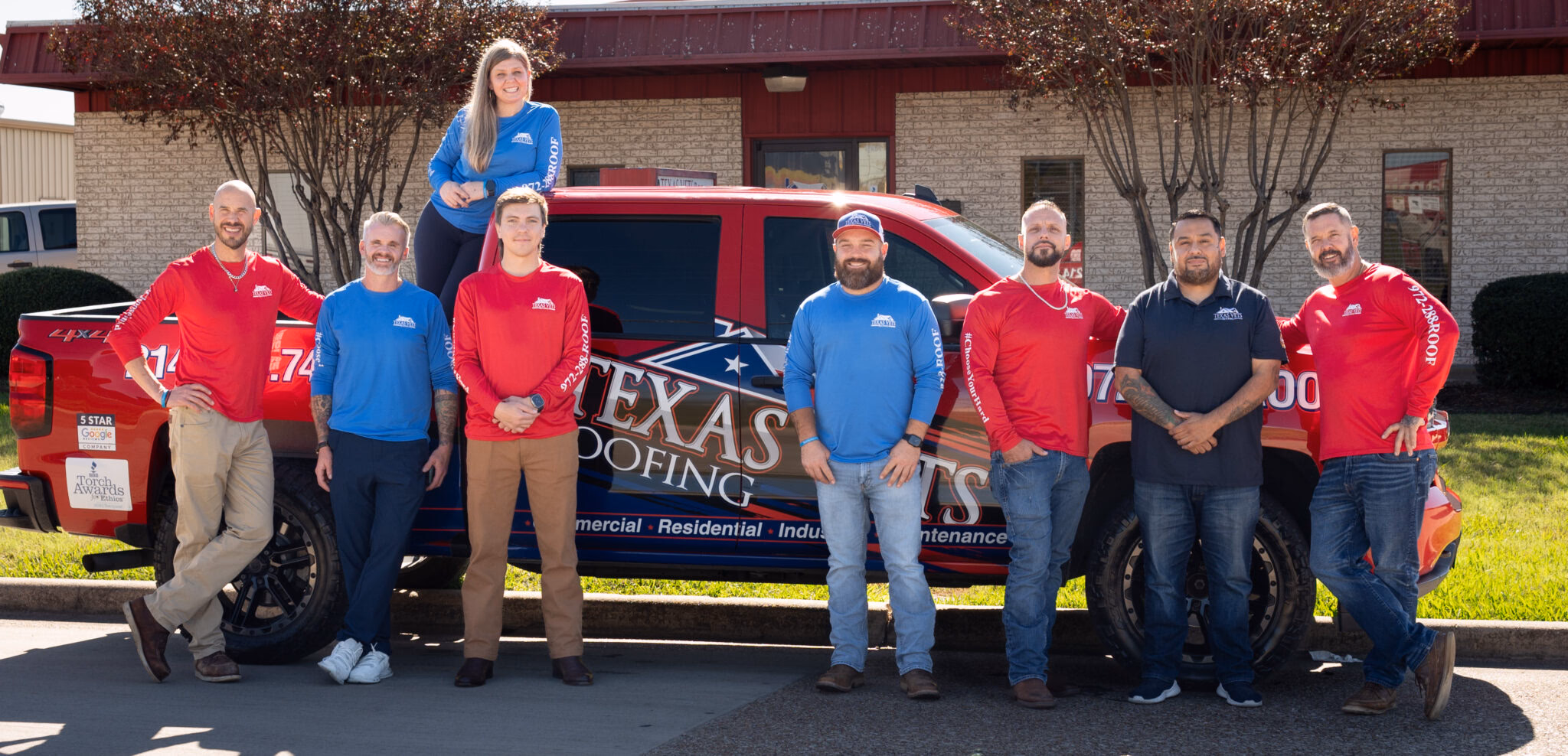 The Texas Vets Roofing team beside their branded truck with Google and BBB award decals